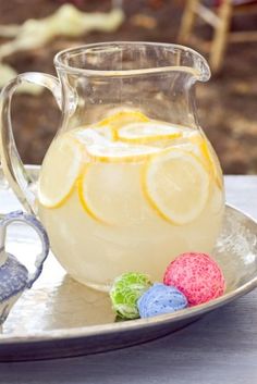 a pitcher of lemonade and some candy on a plate