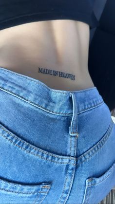 a woman's stomach with the words made in heaven tattooed on her lower back