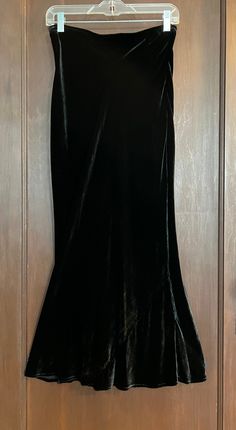 This lovely black 'velvet' full-length skirt from CITRON Santa Monica, circa 1990s, definitely has that Art Deco look and feel to it. It has a gusseted detail at the bottom to give it that bias cut swirl. The hips on the skirt are fuller than that of the model (34-28-34). The waistband has no stretch left to it, but perhaps if you are handy with a needle and thread you can add a piece of elastic. It is made of 82% Rayon and 12% Silk - 100% earth friendly! Closure: Pull On Occasion: Dinner, Dancing, Wedding, Theater, Cocktail Party Size: XS Accents: Gusset at Hemline Size Type: Regular or Petite Skirt Style: Tube/Mermaid Rise: High (Greater than 10.5 in) Waist Size: 28 in Length: 38.5 in Season: All Seasons Garment Care: Dry Clean Only Color: Black Material: 82% Rayon and 12% Silk Front Typ Whimsigoth Dresses, Velvet Skirt Outfit Winter, Whimsigoth Skirt, Corp Goth Work Outfits, Long Black Velvet Skirt, 2000s Goth Fashion, Velvet Black Skirt, Velvet Skirt Outfit, Mermaid Maxi Skirt