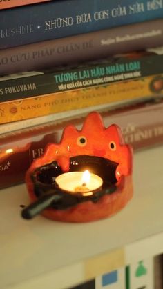 a candle that is sitting on top of a table next to some books and other items