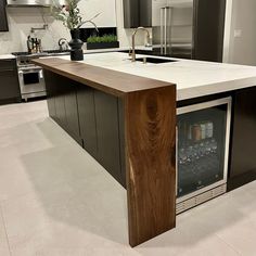 a modern kitchen with an island and wine cooler