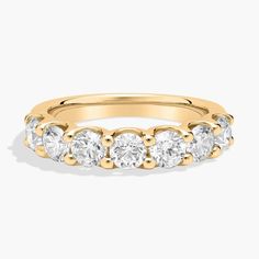 a yellow gold ring with five stones on the side and two rows of diamonds in each band