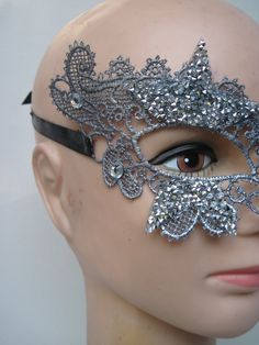 * This stiff silver lace half mask has been designed with five pointed silver beaded stars which have been trimmed and stationed around each eye. Down the front of the mask four faceted crystals accent the shape of the nose. * To secure the mask there are two black satin ribbons on each side to be tied in the back. * A great piece for a Masked Ball, a Night at the Opera, Class Reunion, Birthday Celebration, Halloween, New Year's Celebrations, Parade or Festival, Costume party or Play, Carnivale, Elegant Silver Eye Mask, Silver Masks And Prosthetics For Mardi Gras Party, Silver Masks And Prosthetics For Carnival Party, Silver Masks For Costume Party, Silver Mask For Costume Party, Silver Gothic Mask For Costume Party, Silver Gothic Mask For Masquerade, Elegant Silver Masks And Prosthetics For Party, Elegant Silver Masks And Prosthetics For Mardi Gras