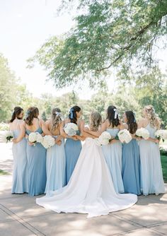 a group of bridesmaids standing in front of a tree