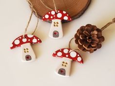 three red and white mushroom ornaments next to a pine cone