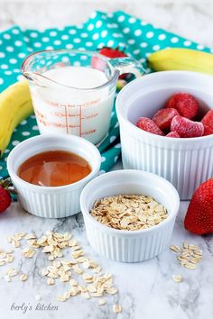 three bowls filled with oatmeal, strawberries, and yogurt