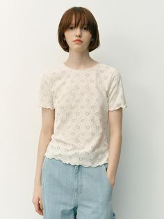 This product is a Wantirna lace t-shirt, which offers a refreshing take on casual wear with its all-over lace design. The t-shirt's classic cut is elevated by the intricate eyelet details, providing a feminine touch. The scalloped hem adds a playful finish to this charming and versatile piece. - The t-shirt is adorned with an eyelet lace pattern, creating a delicate and airy feel.- A round neckline and short sleeves maintain a traditional t-shirt shape, making it easy to incorporate into any wardrobe.- The scalloped hemline enhances the garment with a decorative edge.- Crafted from a lightweight fabric, it's comfortable for all-day wear and perfect for layering or as a standalone piece in warm weather. Casual Pointelle Knit T-shirt For Spring, Casual Pointelle Knit T-shirt For Summer, Feminine Summer Tops With Eyelet Details, Fitted Lace Top T-shirt For Spring, Feminine Eyelet Tops For Summer, Crew Neck Tops With Lace Trim, Spring Lace Trim Crew Neck Top, Feminine Relaxed Fit T-shirt For Spring, White Feminine Top With Cutwork Hem