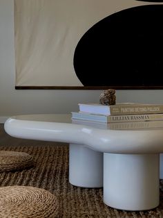 three books are stacked on top of each other in front of a coffee table with two stools