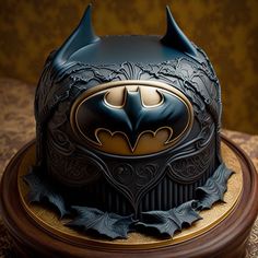 the batman cake is decorated with gold and black icing on it's base