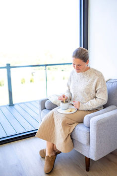 an older woman sitting in a chair eating food