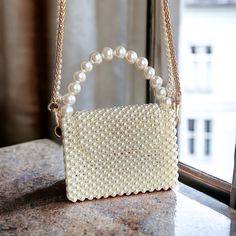 Explore our exquisite collection of handmade bags, featuring unique designs perfect for any occasion. Elevate your style with our elegant Women's Bag, ideal for weddings and special events. Our White Pearl Handbag is a luxurious accessory that adds a touch of sophistication to your ensemble. Whether you're a bride looking for the perfect bag or searching for a Valentine's Day gift, our range of trendy and carefully crafted bags ensures you stand out at any evening party. Embrace the allure of ou Beige Mobile Phone Box Bag As Gift, Chic Pearl Evening Bag For Gift, Elegant Tote Shoulder Bag With Pearl Handle, Luxury Pearl Evening Bag As Gift, Chic Pearl Evening Bag As Gift, Elegant Beige Bag With Mobile Phone Holder, Elegant Beige Bag With Phone Pocket, Luxury Bags With Pearl Handle, Elegant Tote Evening Bag With Pearl Handle