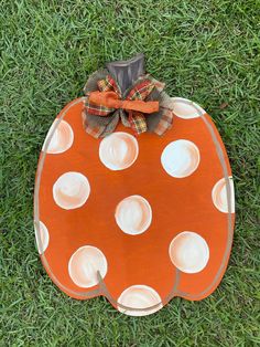 an orange and white polka dot pumpkin sitting in the grass