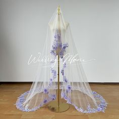 a white veil with purple flowers on it and a wooden floor in front of it