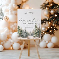 a welcome sign is on an easel in front of christmas trees and snow - covered balls