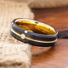 a black and gold wedding band with a diamond