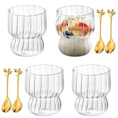 four glass bowls with gold spoons and one bowl filled with fruit in the middle