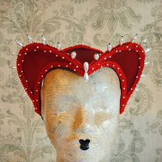 This striking red heart shaped attifet headdress is a great piece to top off your Queen of Hearts costume or any other costume in the red color palette. It is covered with candy apple red silk shantung and embellished with red trimming all around the edges.This unique piece wouldn't be complete without all those wonderful pearl bead details that add some royal flair to it's elegance. The headpiece is very light and comfortably stays in place with an adjustable elastic that goes under the hair and at the back of the neck. You can adjust the strap to be as tight as you want. Also available in other color combinations in the shop or just send me a message to talk about a custom piece that will match your costume! This item is sent packaged securely and sent out with DHL Express, delivered in Fairytale Costume, Gothic Headdress, Top Hat Costume, White Gothic, Fairy Tale Costumes, Queen Of Hearts Costume, Bridal Headdress, Red Colour Palette, Vampire Costume