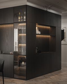 an empty room with some shelves and bottles on the wall next to a dining table