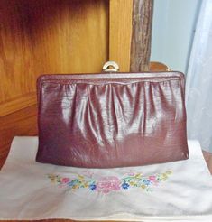 "This is a lovely chocolate brown \"Mardane\" handbag from the 50's or 60's. It's converts from a clutch to a shoulder bag in a flash, with a tuck-in gold chain. It's a subtle soft crackled leather purse with a leather covered frame and beige fabric lining. It has a gold half moon clasp and a unique flip-up mirror attached to the inside frame. It's a mirror on one side and the word \"Mardane\" is etched into metal on the other. It's still in great condition. It has a few minor specks inside. \"M Retro Brown Formal Bags, Vintage Brown Shoulder Bag For Evening, Vintage Evening Shoulder Bag In Vintage Brown, Retro Brown Clutch For Evening, Retro Brown Vintage Bags, Brown Mid-century Bags For Formal Occasions, Brown Mid-century Evening Bags, Mid-century Brown Evening Bags, Retro Clutch Bag For Vintage Events