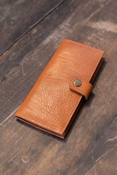 Natural-grained unlined wallet. It features a front snap closure, 8 card slots, 2 bill compartments plus a zippered interior pocket. Travel Wallet In Cognac With Leather Lining, Cognac Wallet With Leather Lining For Daily Use, Brown Travel Wallet With Coin Pocket, Classic Coin Purse With Card Slots For Daily Use, Brown Leather-lined Wallet For Travel, Brown Bifold Coin Purse For Travel, Cognac Leather Wallet For Daily Use, Travel Wallets With Leather Lining In Brown, Classic Coin Purse With Rfid Blocking