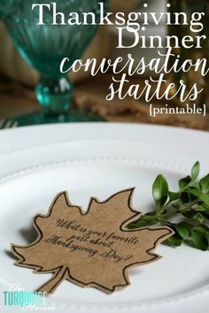 a white plate topped with a green leaf and a tag that says thanksgiving dinner conversation starter printable