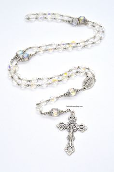 "Each Rosary includes FREE PERSONALIZATION up to TEN letter beads This Catholic Rosary is handmade using sparkling Czech Crystal beads on silver wire. Each Hail Mary bead is a clear Czech Crystal bead that is facet cut and surprisingly smooth given its rigid appearance. The Our Father beads are also Czech Crystal beads that are somewhat tubular in shape and are surrounded by elegant silver decorative metal beads. The Czech Crystal beads used in this Rosary are aurora borealis coated, giving them Personalized Silver Rosary For Confirmation, Wedding Spiritual Cross Rosary, Spiritual Cross Rosary For Confirmation, Rosary Gift, Custom Rosary, Catholic Rosary, Our Father, Hail Mary, Rosary Catholic