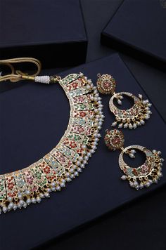 Borrowing from the age old technique of Pakistani aari and Punjabi jadau work, this necklace set is based in silver alloy and plated with 22k gold. The combination of these pristine colours paints a lovely picture embellished with shell pearls and semi precious stones. Necklace Closure - Adjustable Dori Earrings Closure - Push Back Style Tip - Versatility and elegance being the strong suit, we leave a lot to your imagination for how you want to dress your jewels your way and embracing your perso Multicolor Necklace With Intricate Design For Ceremonial Occasions, Ceremonial Multicolor Necklace With Intricate Design, Multicolor Temple Jewelry Necklace, Multicolor Round Temple Jewelry Necklaces, Multicolor Round Necklace With Intricate Design, Heavy Multicolor Jewelry For Ceremonial Occasions, Bold Multicolor Ceremonial Jewelry, Bollywood Style Multicolor Necklaces With Intricate Design, Multicolor Heavy Temple Jewelry