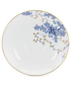 a blue and white plate with gold trimmings on the rim is shown in front of a white background