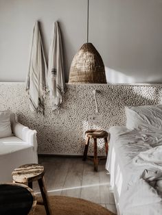 a white bed sitting next to a chair in a bedroom