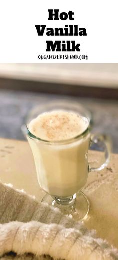 hot vanilla milk in a glass cup on top of a table next to a towel