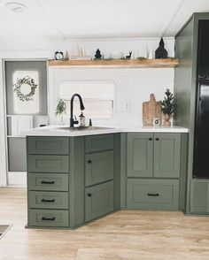 a kitchen with green cabinets and white counter tops