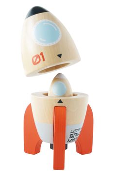 a wooden toy rocket ship sitting on top of an orange stand