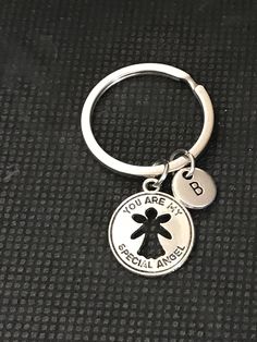 a silver keychain with a black and white design on it that says, you are my special angel