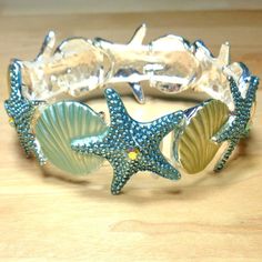 Beach Fashion Nautical Blue Green Starfish With Cz Stone And Seashells Sea Life Stretch Rhodium Bracelet This Beautiful Rhodium Blue Green Starfish And Seashells Bracelet Features 6 Blue Green Starfish With A Single Cz Stone In The Middle And 6 Seashells All Linked Together On This Stretch Bracelet. The Bracelet Is 8 1/2 Inches Long And Is A One Size Fits Most Stretch Bracelet For A Secure Fit On Your Wrist. The Starfish Measure 1 Inch Wide And High And The Seashells Measure 3/4 Inches Wide And Seashells Bracelet, Rhodium Jewelry, Seashell Bracelet, Nautical Accessories, Sea Jewelry, Ocean Jewelry, Beach Fashion, Key West, Cz Stone