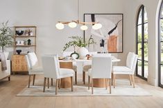 a dining room table with white chairs around it