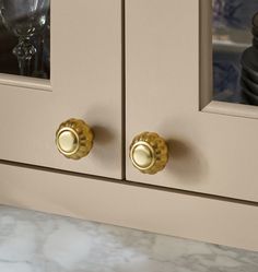 a close up of a cabinet with two knobs and a glass in the door