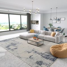 a living room filled with furniture next to a large glass wall window overlooking the city