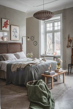 a bed sitting next to a window on top of a wooden table in a bedroom