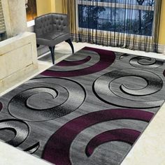 a living room with a black and white rug on the floor next to a chair