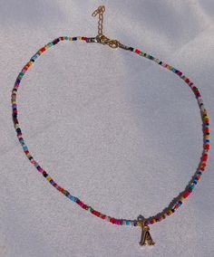 Add a burst of color to your wardrobe with this vibrant Personalized Rainbow Seed Bead Necklace. Thoughtfully handcrafted to celebrate individuality, this necklace features an array of multicolored seed beads, customizable with a name or word of your choice. Each bead is carefully selected to create a lively, eye-catching design that adds a fun and personal touch to any outfit. Why You'll Love It: Vibrant Multicolors: Each necklace is made with bright, multicolored seed beads, creating a striking rainbow effect that's sure to turn heads. Personalized Charm: Customize your necklace with a name, word, or initials, making it a truly unique and meaningful accessory. Handcrafted Quality: Meticulously handcrafted with care and precision, ensuring a durable and high-quality piece that you can che Multicolor Letter Beads Necklace For Festival, Festival Necklace With Round Letter Beads, Multicolor Letter Beads Jewelry, Bohemian Multicolor Necklace With Letter Beads, Multicolor Letter Beaded Jewelry, Colorful Letter Beads For Festival, Bohemian Multicolor Letter Beads Necklace, Multicolor Heart Beads Necklaces For Jewelry Making, Colorful Letter Beads Necklaces For Jewelry Making