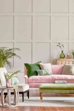 a living room with pink couches and green pillows on the back of it's sofa