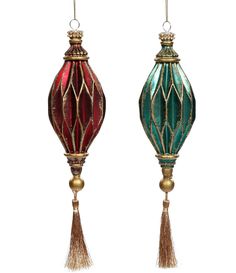 two christmas ornaments with tassels hanging from the top, one red and one green