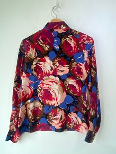 Vintage Cacharel Floral Silk Blouse! So cute! Long sleeves, a classic collar, and buttons up the front. Would best fit a size small, please refer to measurements. In overall great vintage condition with minor signs of wear on the arm pits. Approx. Measurements: Underarm to Underarm: 19" Sleeve Length: 24.5" Length: 23.5" Vintage Floral Print Blouse For Work, Vintage Button-up Office Blouse, Vintage Collared Blouse For Office, Vintage Button-up Blouse For Office, Vintage Blouse With Button Cuffs For Work, Vintage Workwear Blouse With Button Cuffs, Fitted Floral Print Blouse With Spread Collar, Vintage Long Sleeve Blouse With Covered Buttons, Vintage Multicolor Blouse For Daywear