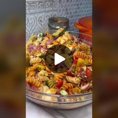 a bowl filled with pasta and vegetables on top of a table