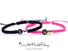 two pink and black bracelets with hearts on them