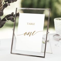 a table with a sign and some flowers