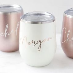 three wine glasses with names on them sitting next to each other in front of a white background