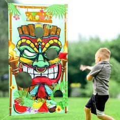 a young boy is playing with a kite in the grass