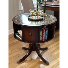 a table with two books on it and some candles in the middle, sitting on a hard wood floor