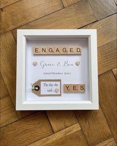 a white frame with two wooden pegs attached to it that says engaged grace and be